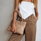 Bembien Ella Bag Grande Weave in Caramel held in the arm of a standing woman