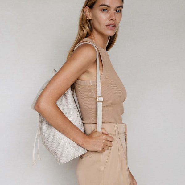 Bembien Frida Backpack in Cream worn as a backpack by a standing woman