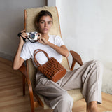 Bembien Bonita Bag Oversized Knot in Sienna worn by a seated woman holding camera